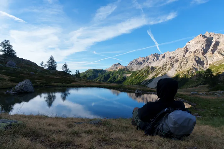 A still alpine lake at dawn with jagged peaks reflected in the water