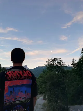 Raul Carini looking out at a mountain skyline at dusk, Italy